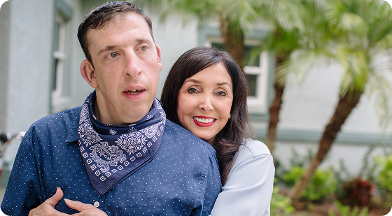 Patient living with Dravet syndrome | Smiling Woman Hugging Man